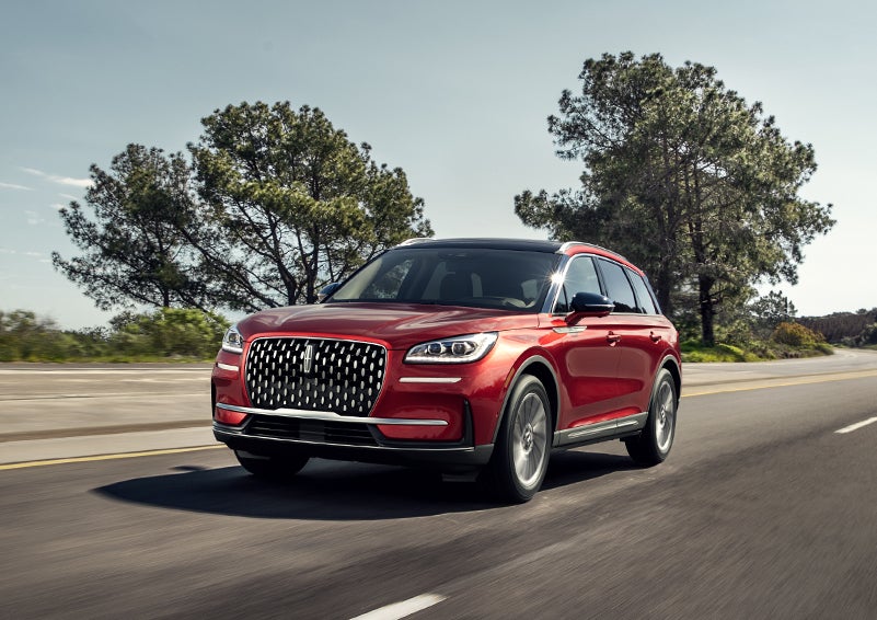 A 2023 Lincoln Corsair® SUV is shown being driven on a country road. | Libertyville Lincoln Sales, Inc. in Libertyville IL