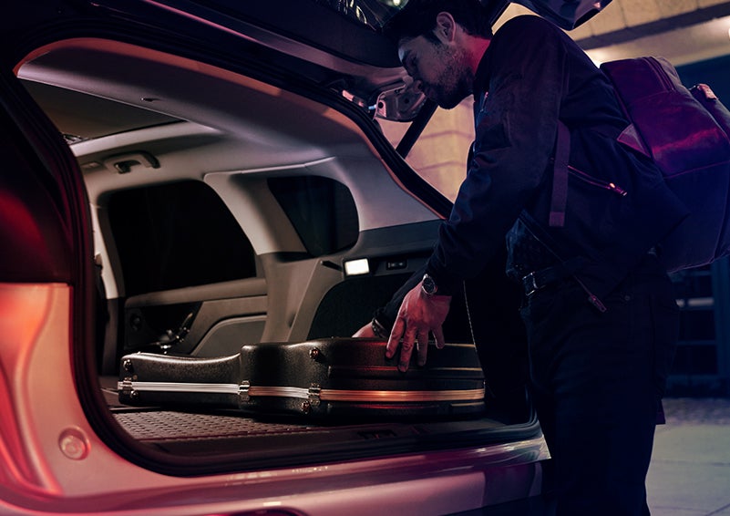 A man is shown loading cargo into the rear of a 2023 Lincoln Corsair® SUV with the second-row seats folded flat. | Libertyville Lincoln Sales, Inc. in Libertyville IL