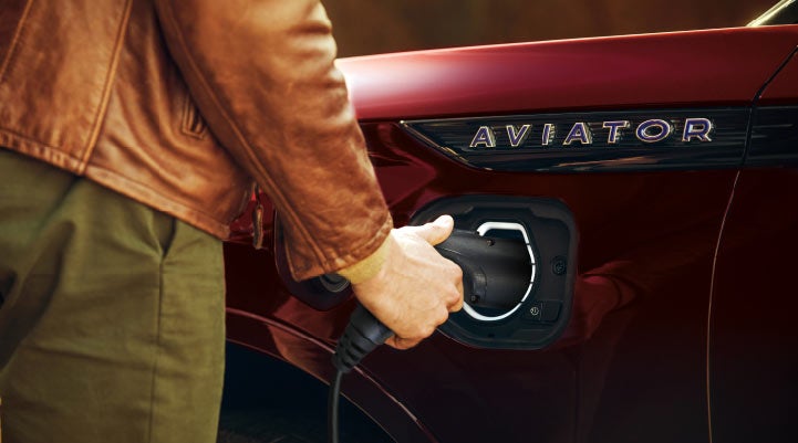A hand is shown plugging in the charger into the charging port of a 2021 Lincoln Aviator | Libertyville Lincoln Sales, Inc. in Libertyville IL
