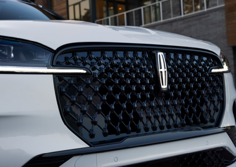 The black grille of a white 2025 Lincoln Aviator® SUV is shown with its fog lights on. | Libertyville Lincoln Sales, Inc. in Libertyville IL