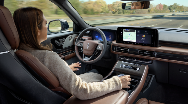 A woman is seen sitting in the driver’s seat of her 2025 Lincoln Aviator® SUV with her hands off the steering wheel. | Libertyville Lincoln Sales, Inc. in Libertyville IL