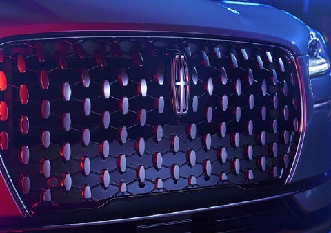 The grille of a 2025 Lincoln Corsair® SUV reflects neon light at night. | Libertyville Lincoln Sales, Inc. in Libertyville IL