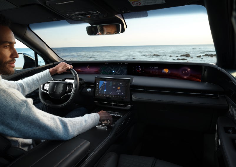 A driver of a parked 2025 Lincoln Nautilus® SUV takes a relaxing moment at a seaside overlook while inside his Nautilus. | Libertyville Lincoln Sales, Inc. in Libertyville IL