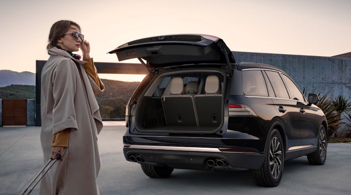 A woman approaches a 2026 Lincoln Aviator® SUV with its rear liftgate open. | Libertyville Lincoln Sales, Inc. in Libertyville IL