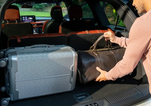 A man loads luggage into the rear of a 2026 Lincoln Aviator® SUV through the opened rear liftgate. | Libertyville Lincoln Sales, Inc. in Libertyville IL