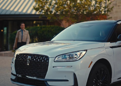 A person approaches a 2026 Lincoln Corsair® SUV as the Lincoln Embrace light sequence takes place. | Libertyville Lincoln Sales, Inc. in Libertyville IL