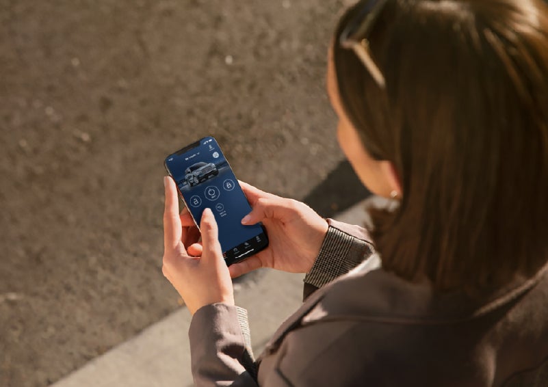 A person is shown interacting with a smartphone to connect to a Lincoln vehicle via the Lincoln Way® app. | Libertyville Lincoln Sales, Inc. in Libertyville IL