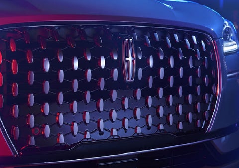 The grille of a 2025 Lincoln Corsair&reg; SUV reflects neon light at night. | Libertyville Lincoln Sales, Inc. in Libertyville IL