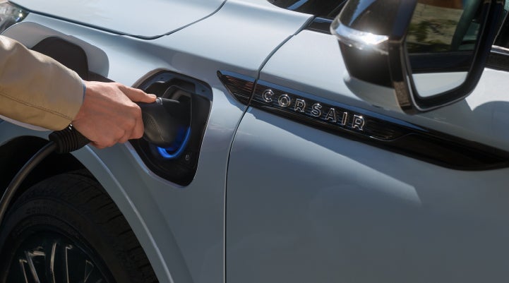 A hand is plugging in a 2026 Lincoln Corsair® Grand Touring Plug-in Hybrid SUV. | Libertyville Lincoln Sales, Inc. in Libertyville IL