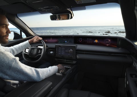 A driver of a parked 2026 Lincoln Nautilus® SUV takes a relaxing moment at a seaside overlook while inside his Nautilus. | Libertyville Lincoln Sales, Inc. in Libertyville IL