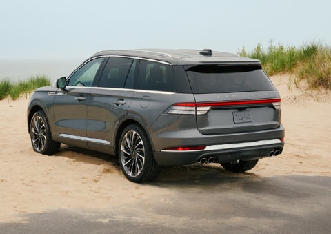 A 2027 Lincoln Aviator® SUV is parked next to sand dunes. | Libertyville Lincoln Sales, Inc. in Libertyville IL