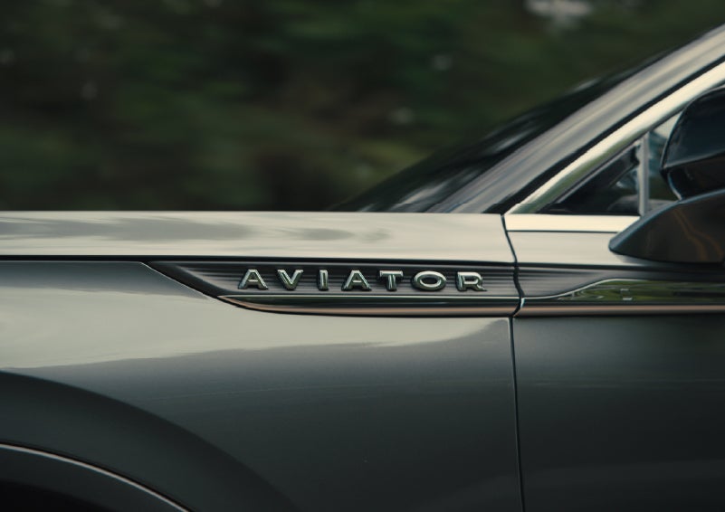 The driver’s side door and fender badging of a gray 2027 Lincoln Aviator® SUV are showcased. | Libertyville Lincoln Sales, Inc. in Libertyville IL