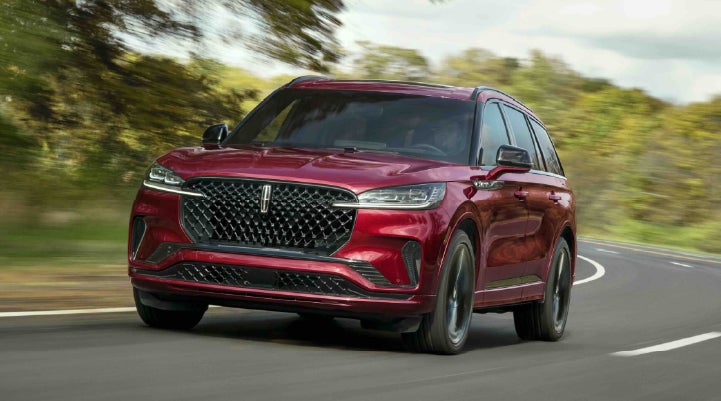 A 2027 Lincoln Aviator® SUV is being driven on a country road | Libertyville Lincoln Sales, Inc. in Libertyville IL